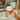 Hand holding a jar of 'Honor' cream in front of a mirror. lavender